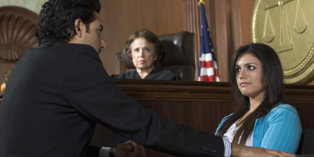 Advocate with witness and judge sitting in the background Advocate with witness and judge sitting in the background
